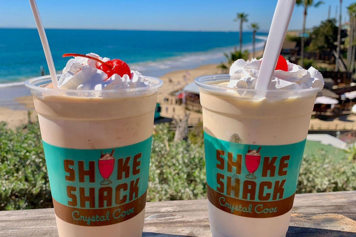 two milk shakes with the ocean in the background